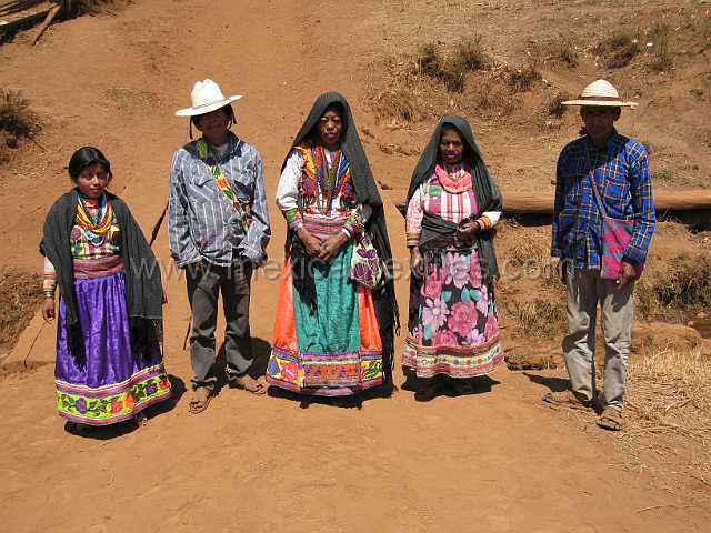 cora_family1.JPG - This family was on the way to the festival . The colorful Cora costume is obvious here in this picture. Notice on the right the skirt is the older style , while on the left there is a broad ban of floral applique.
