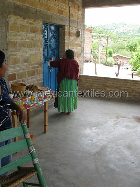 ahuelican_nahuatl05.JPG - This woman almost participated ,she went in the bring something out and then refused to come out. She willingly showed us her daily dress here you can see the long sleeved over blouse and the long skirt with apron.
