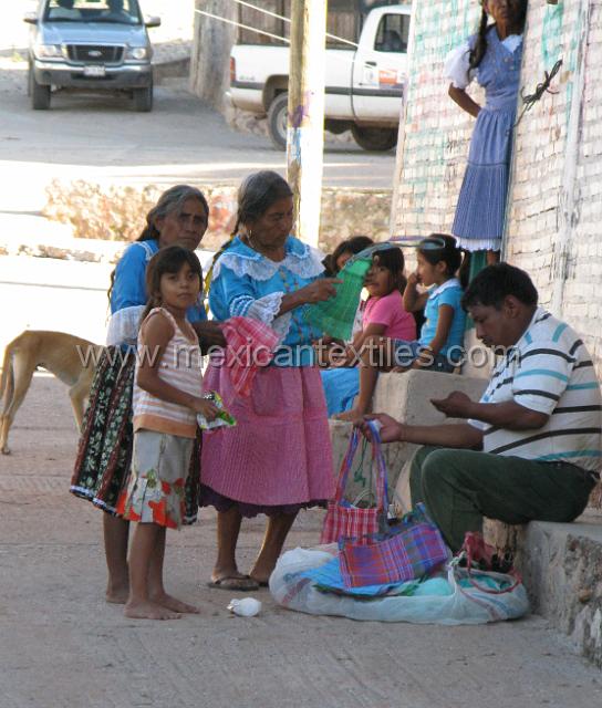 nahuatl_analco82.JPG - Some women buying goods froma local vendor. both the older women are wearing traditional costumes